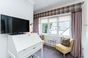 een woonkamer met een tv op een wit dressoir bij Sandown House in Nairn