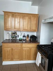 a kitchen with wooden cabinets and a stove at Comfy Guest House by Columbus Circle in New York