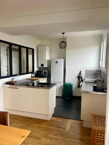 een keuken met witte kasten en een witte koelkast bij Le 30 Rennais - T4 en plein centre ville in Rennes