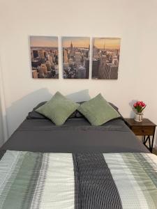 a bedroom with a bed with three pictures on the wall at Comfy Guest House by Columbus Circle in New York