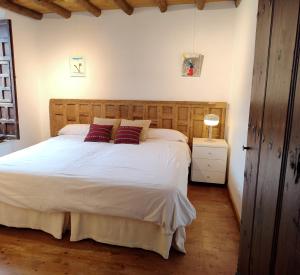 a bedroom with a large white bed with red pillows at Casa Vila do Bispo in Vila do Bispo