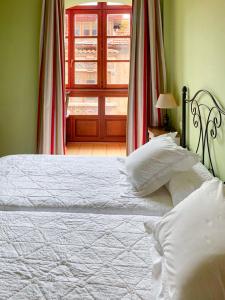 1 dormitorio con cama blanca y ventana en Appto La Gandara Llanes, en Llanes