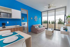 una cucina e un soggiorno con pareti blu e divano di Apartment in Excellent Location a Playa del Carmen
