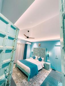 1 dormitorio con 1 cama grande y paredes azules en Atmani waterfront resort, en Cola