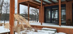 a wooden house with a large window in the snow at Cieślówka in Leżajsk