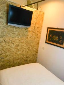 a bedroom with a tv on a stone wall at Luminoso y acogedor bajo en Tetuán by beBalmy in Madrid