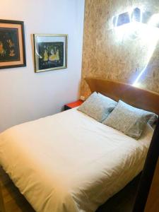 a bedroom with a white bed with two pillows at Luminoso y acogedor bajo en Tetuán by beBalmy in Madrid