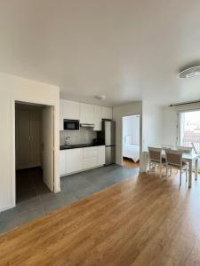 eine Küche und ein Esszimmer mit Tisch und Stühlen in der Unterkunft Appartement moderne avec Balcon proche de Paris in Aubervilliers