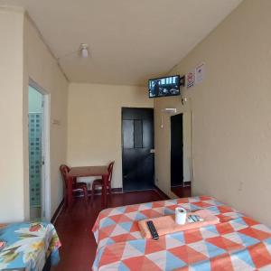 Habitación con cama y TV en la pared. en Hotel Villas de San Juan, Guatemala, en Guatemala