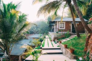 a house with palm trees in front of it at Atmani waterfront resort in Cola