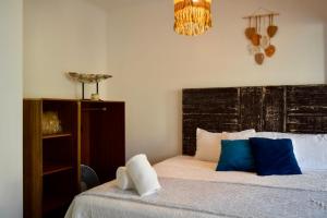 a bedroom with a bed with blue and white pillows at Casa Miranda Balbuena in Guadalajara