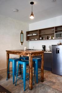a kitchen with a wooden table and blue stools at Casa Miranda Balbuena in Guadalajara