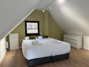 Patyki - Las Możliwości في Zelów: غرفة نوم مع سرير أبيض كبير في العلية