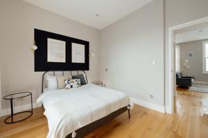 um quarto com uma cama branca e uma cabeceira preta em Contemporary & Chic 1 Bedroom Apartment in Honor Oak em Londres