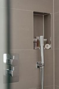 um chuveiro na casa de banho com um espelho e um pente em Contemporary & Chic 1 Bedroom Apartment in Honor Oak em Londres