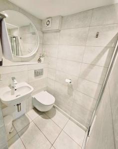 uma casa de banho branca com um WC e um lavatório em "Beachcomber" Cosy Town Centre & Beach Apartment! em St. Ives