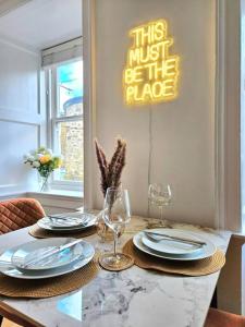 uma mesa de jantar com 2 pratos e taças de vinho em "Beachcomber" Cosy Town Centre & Beach Apartment! em St. Ives