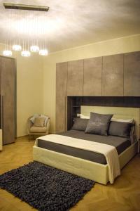 a bedroom with a large bed and a chair at Corso Italia Luxury Suite in Fondi