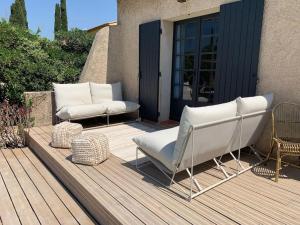 two white chairs sitting on a wooden deck at Superbe villa piscine Climatisation in Six-Fours-les-Plages