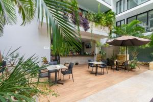 cortile con tavoli, sedie e ombrellone di Apartment in Excellent Location a Playa del Carmen