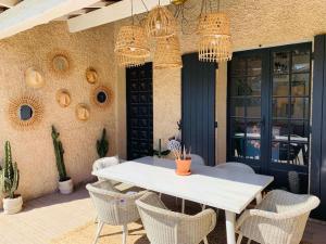 a white table and chairs on a patio with chandeliers at Superbe villa piscine Climatisation in Six-Fours-les-Plages