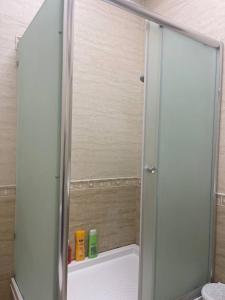 una ducha con puerta de cristal en un baño en Classical apartment in heart of Baku, en Baku 23 fotos más
