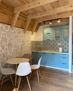 ジャブリャクにあるWonderwood Cabin 2の青いキャビネットとテーブルと椅子のあるキッチン