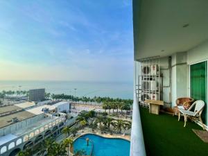 uma varanda com vista para um hotel com piscina em Beautiful sea view beach front condo em Pattaya Sul