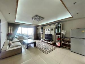 uma ampla sala de estar com um sofá e um frigorífico em Beautiful sea view beach front condo em Pattaya Sul