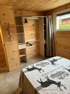 a bedroom with a bed in a wooden room at L'OURSIERE à Saint MAMET in Saint-Mamet +1 photo