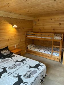 two bunk beds in a log cabin at L'OURSIERE à Saint MAMET in Saint-Mamet