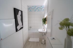 a white bathroom with a sink and a toilet at Herbstzeit ist Familienzeit - 180qm für Groß und klein in Bad Wörishofen +19 photos