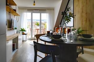 a kitchen and dining room with a table and chairs at Appart - Élégant - Chic - Paris-Disneyland - RER A - Self-Check In - NETFLIX - WIFI Ultra Rapide in Noisy-le-Grand