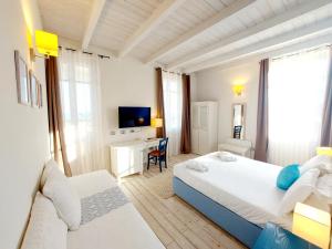 カリアリにあるHotel La Villa Del Mareのベッドルーム1室(ベッド2台、デスク、テレビ付)