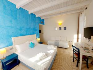 a bedroom with a bed and a desk with a table at Hotel La Villa Del Mare in Cagliari