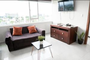 ein Wohnzimmer mit einem Sofa und einem Tisch in der Unterkunft Gran suite en Samborondonķo in SamborondÃ³n
