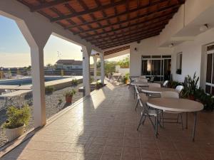 a patio with tables and chairs and a pool at Por de Sol - Aux repos des skippers in Cidade Velha