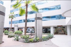 a building with palm trees in front of it at Gran suite en Samborondonķo in SamborondÃ³n