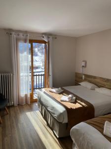 a hotel room with two beds and a balcony at Le Relais du Galibier in Valloire