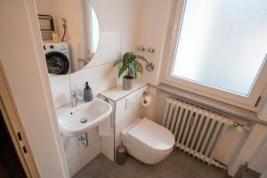 een kleine badkamer met een toilet en een wastafel bij MOREHOME Apartments, Center,Parking 180qm in Bad Wörishofen