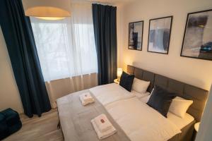 een slaapkamer met een bed met twee handdoeken erop bij MOREHOME Apartments, Center,Parking 180qm in Bad Wörishofen