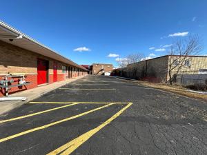 an empty parking lot next to a brick building at HOTEL CLASSIC COMFORT in Cornwall