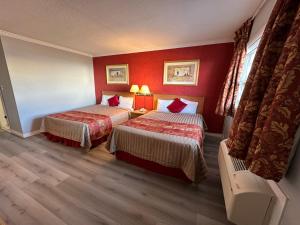 a hotel room with two beds with red walls at HOTEL CLASSIC COMFORT in Cornwall