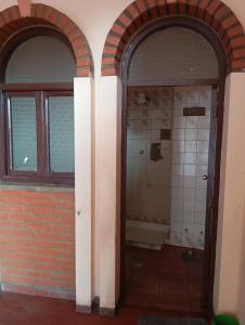 uma casa de banho vazia com duas portas arqueadas e uma banheira em Hermoso Apartamento rustico en el centro em Cochabamba