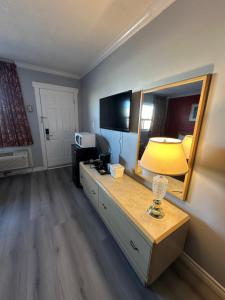 een kamer met een bureau met een lamp en een spiegel bij HOTEL CLASSIC COMFORT in Cornwall