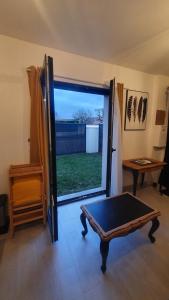 um quarto com uma grande porta de vidro com uma mesa em Charmant T2 tout confort proche centre ville. em Milly-la-Forêt