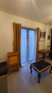 uma sala de estar com uma mesa e uma janela em Charmant T2 tout confort proche centre ville. em Milly-la-Forêt