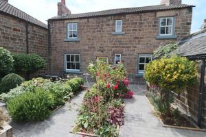 a garden in front of a brick building at Beautiful Character Cottage in Milford