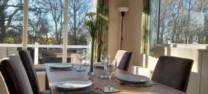a dining room table with chairs and wine glasses at Platinum lodge on Carlton Meres holiday Park in Rendham