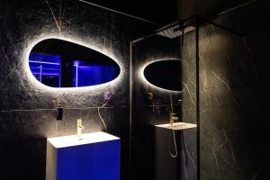 a bathroom with a shower with a blue cabinet and a mirror at Loveroom Ô Diable Des Plaisirs avec jacuzzi in Tourcoing
